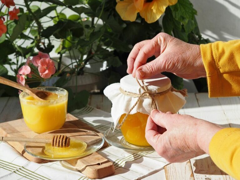 Elderly womans hands wrap glass jar rustic natural flower honey honey cup tea 1048944 22700393